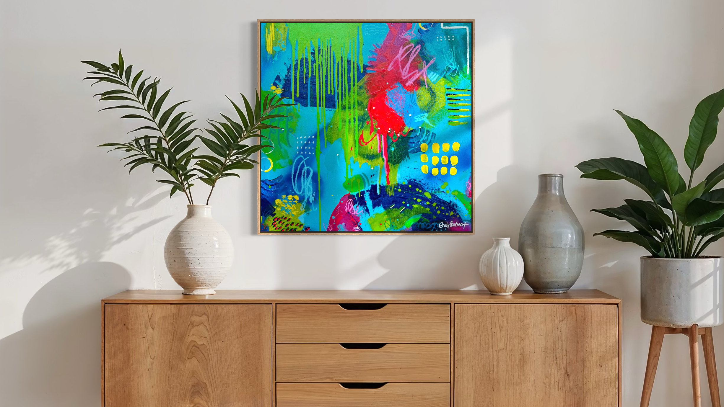 Modern living room with wooden sideboard, colourful abstract painting, and potted plants.