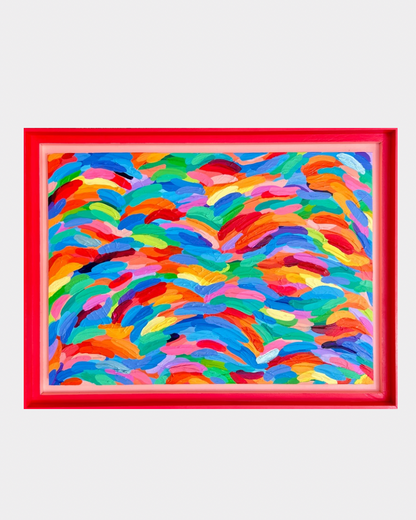 A framed abstract painting featuring a vibrant, multicolored pattern of flowing brushstrokes in red, blue, yellow, green, and orange, enclosed in a bold red frame against a light gray background.