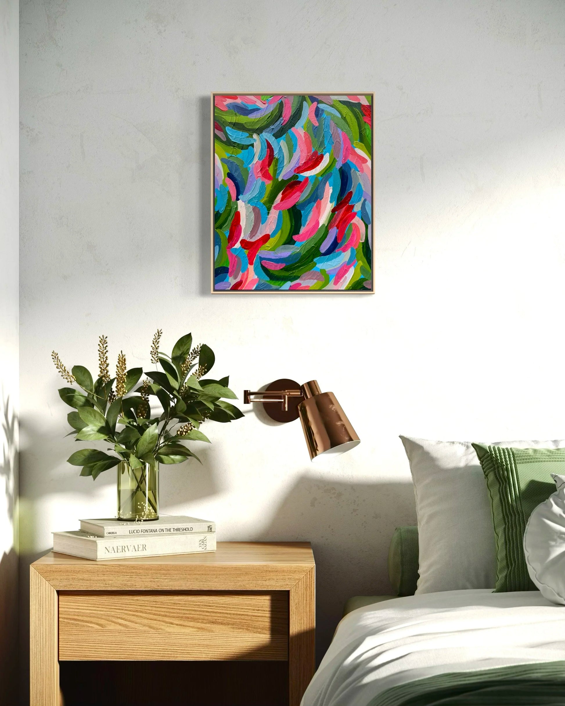 Modern bedroom with a colorful abstract painting on the wall, a bedside table with a lamp and plant, and a bed with pillows.