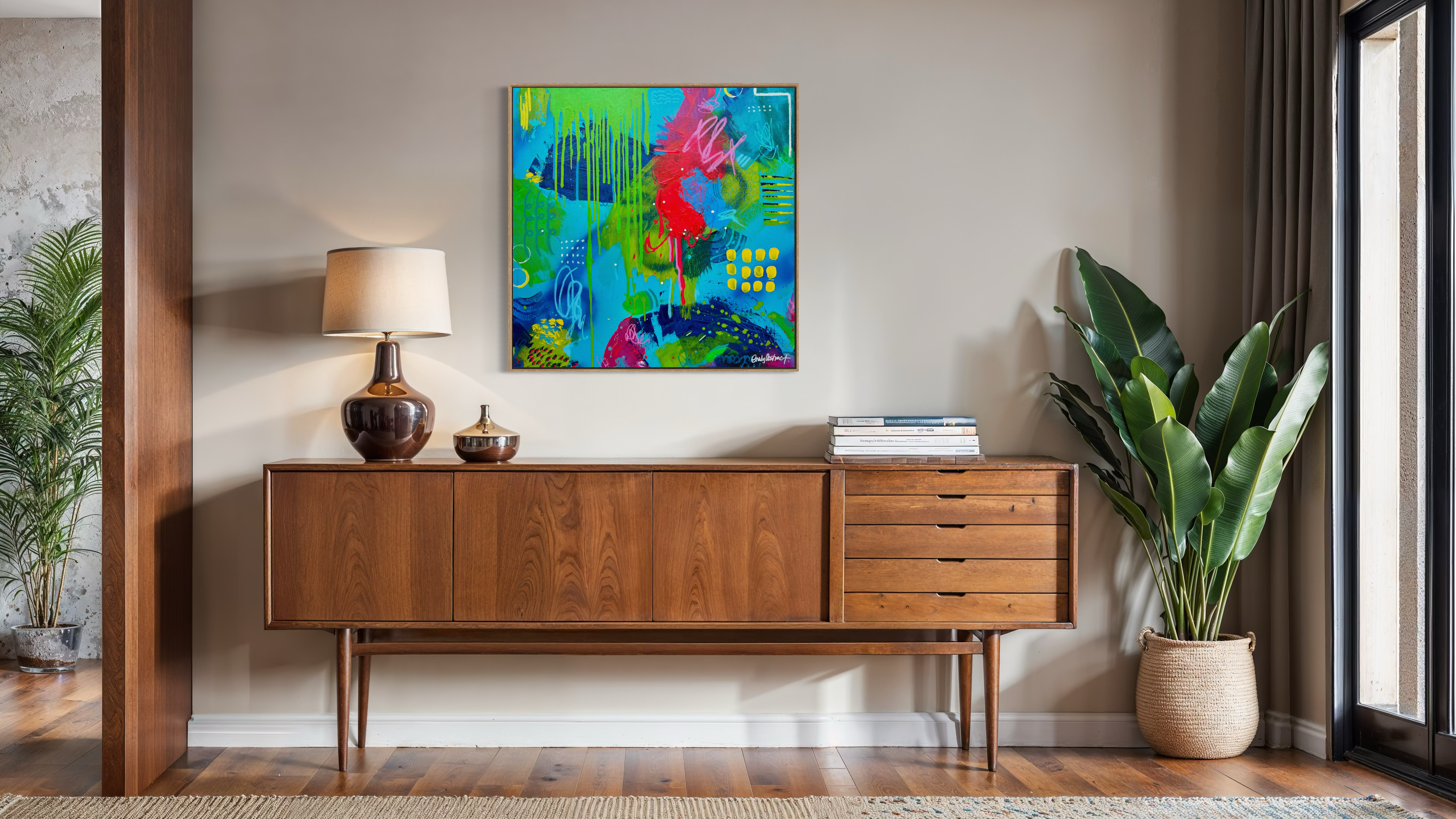 Wooden sideboard with decorative items in a room with a colorful abstract painting on the wall.