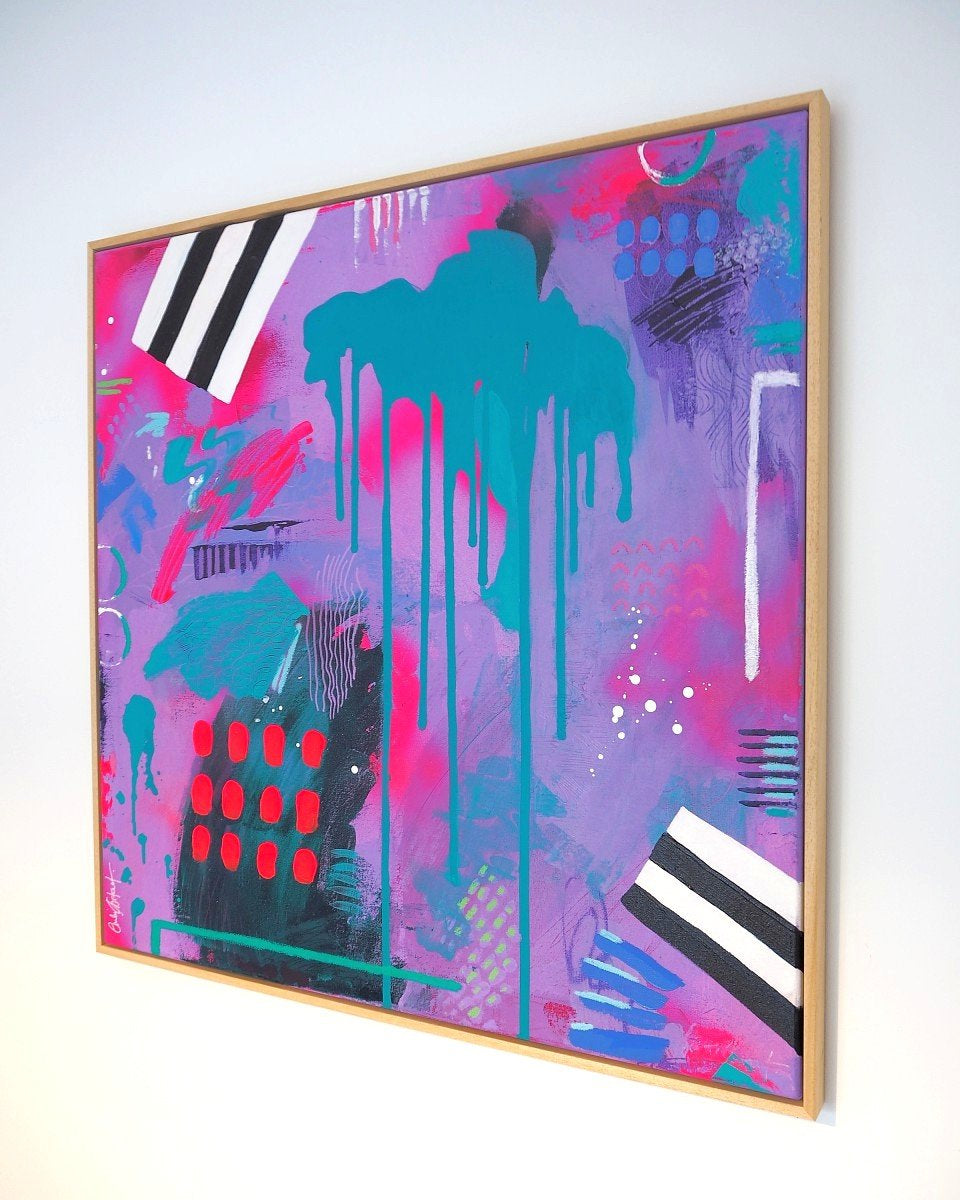 Abstract colourful painting with a wooden frame on a white wall